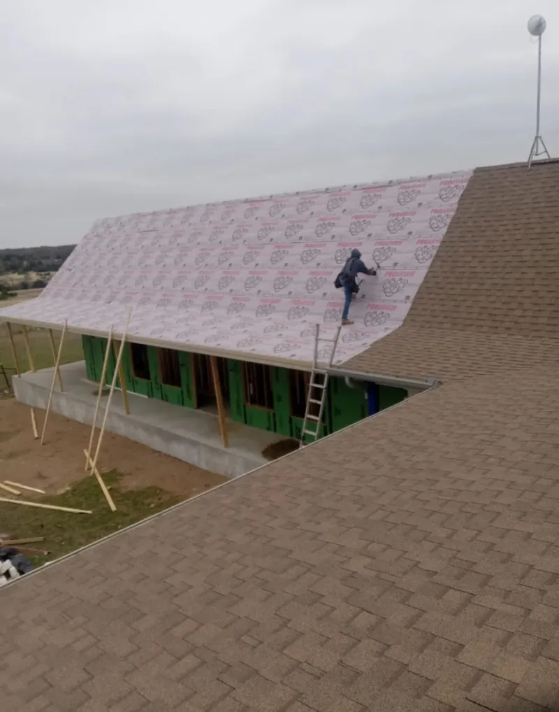 Worker preparing underlayment for a metal roof installation in Kennesaw